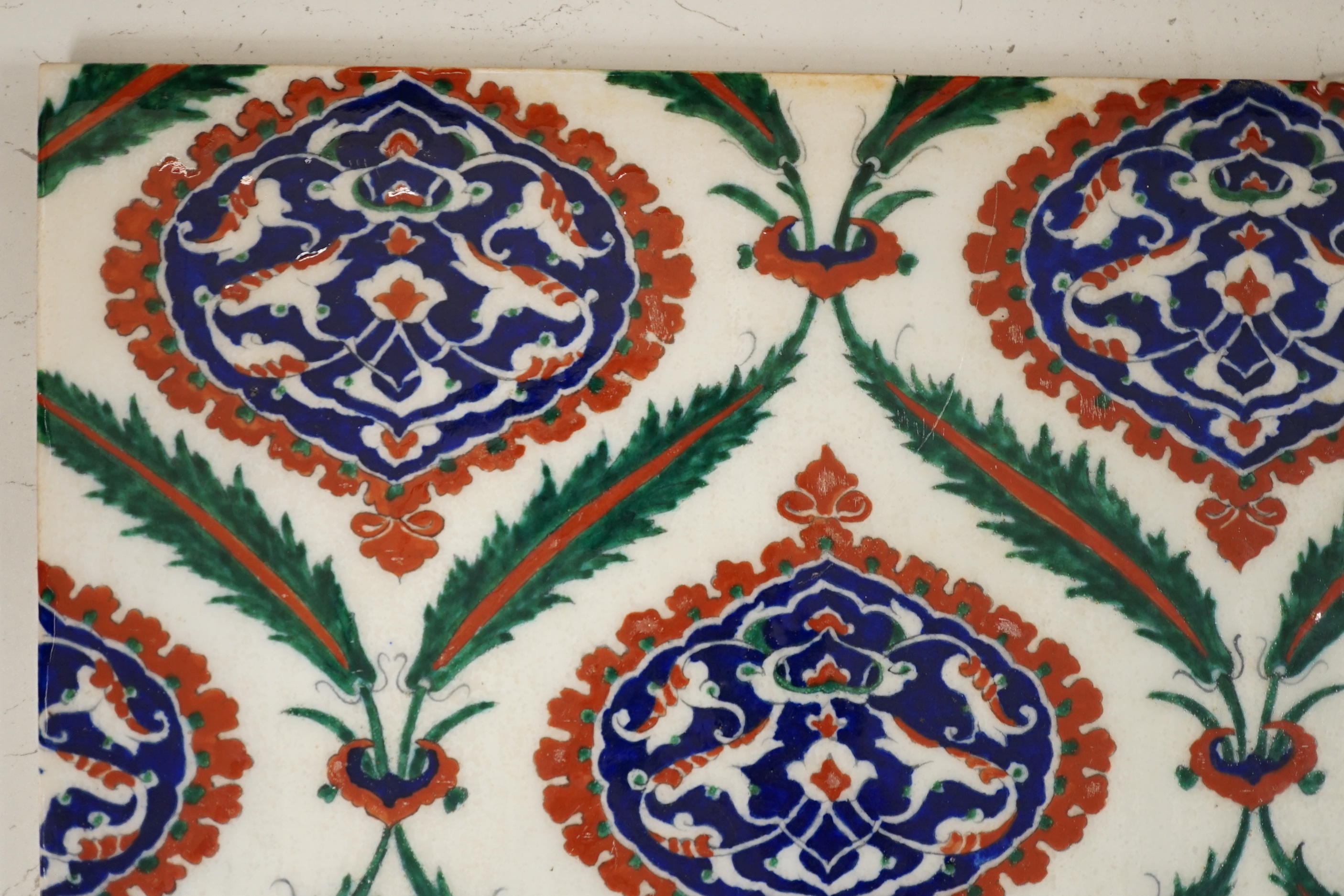 A large Turkish Iznik pottery tile, decorated with stylised flowers, 34cm x 25cm